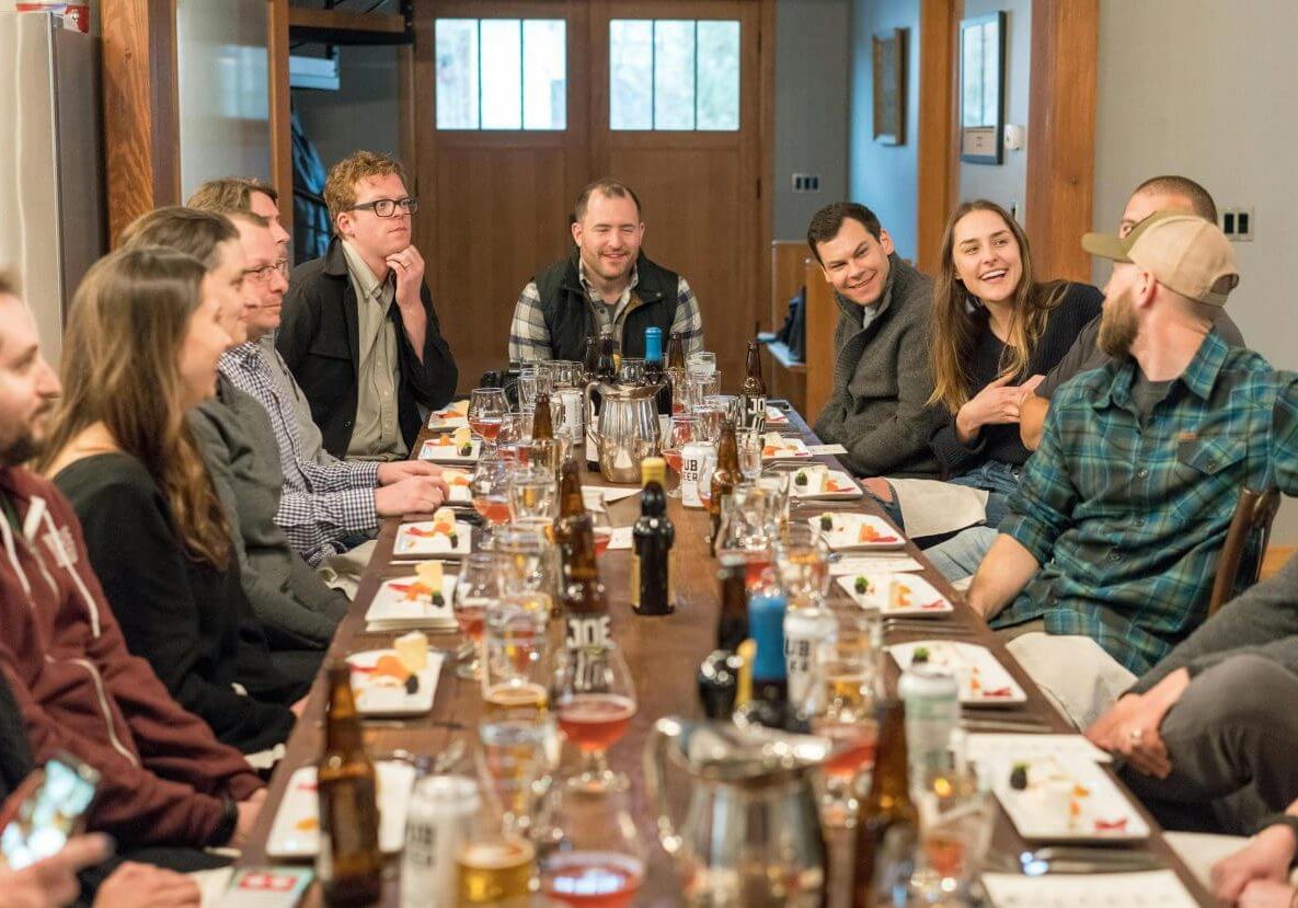 A joyful group of adults enjoying a meal and drinks at a restaurant, fostering communication and friendship.