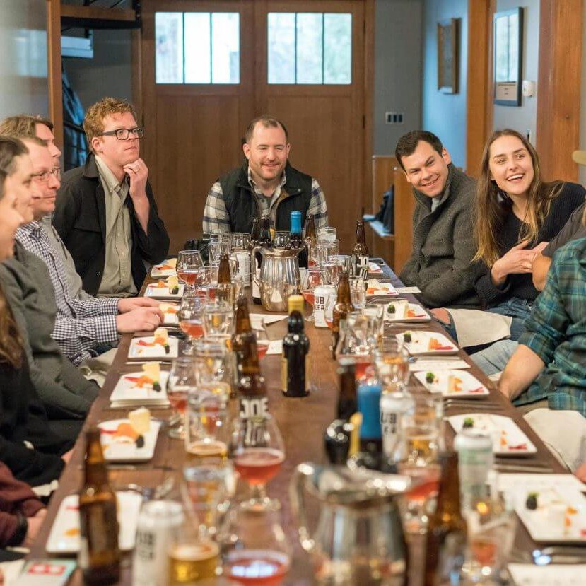 A joyful group of adults enjoying a meal and drinks at a restaurant, fostering communication and friendship.